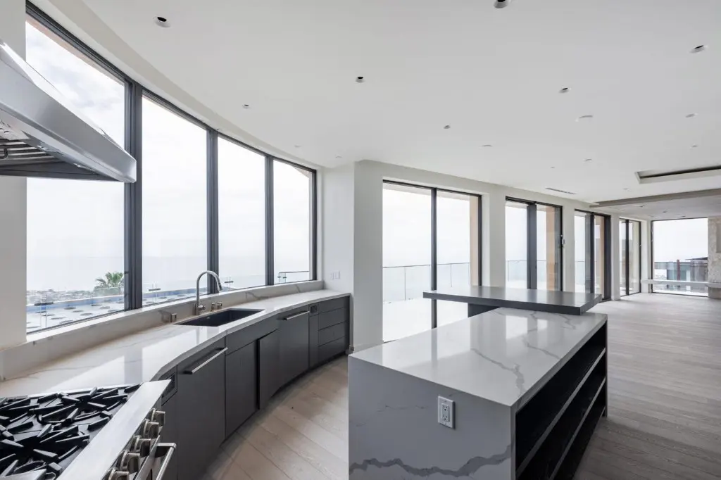 Curved kitchen with a long run of dark-framed windows