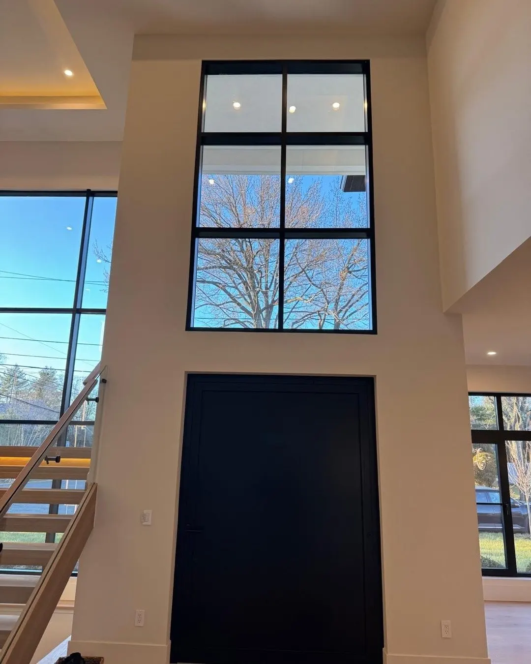 Seattle install: tall black-framed glazing above an entry door
