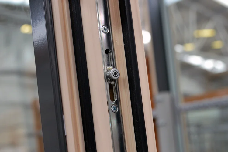 Concealed tilt-and-turn hardware on the edge of a wood sash