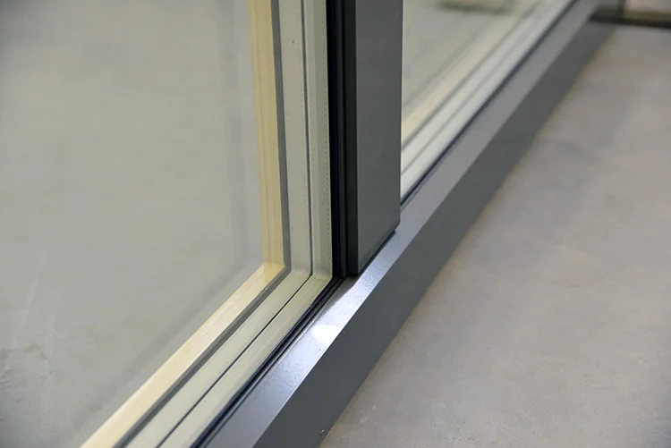 Dark aluminum cladding on the outside of a wood window frame