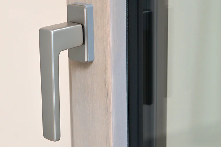 Slim handle on a light wood sash of an aluminum-clad wood window