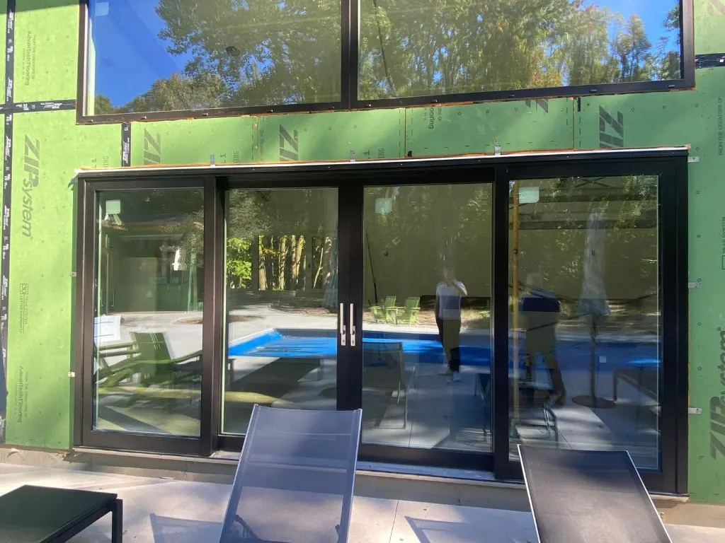 Black aluminum-clad sliding glass doors during construction