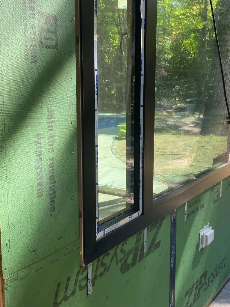 Corner of a black aluminum-clad Synergic window frame during installation