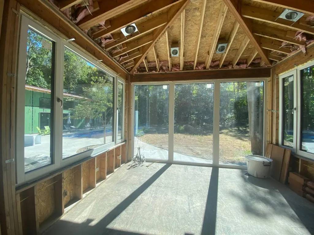 White Synergic frames inside a room under construction, looking out through a glass wall