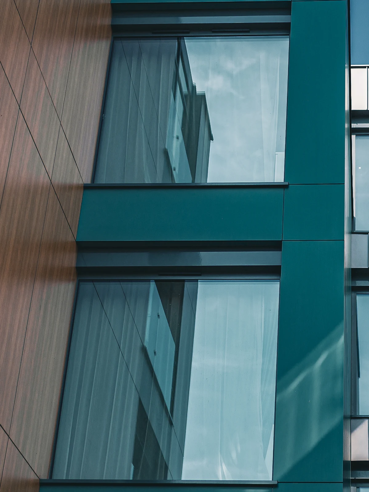 Inspiration, European project overseas: MB-79N Pro aluminum windows set in a teal-clad bay beside wood panels