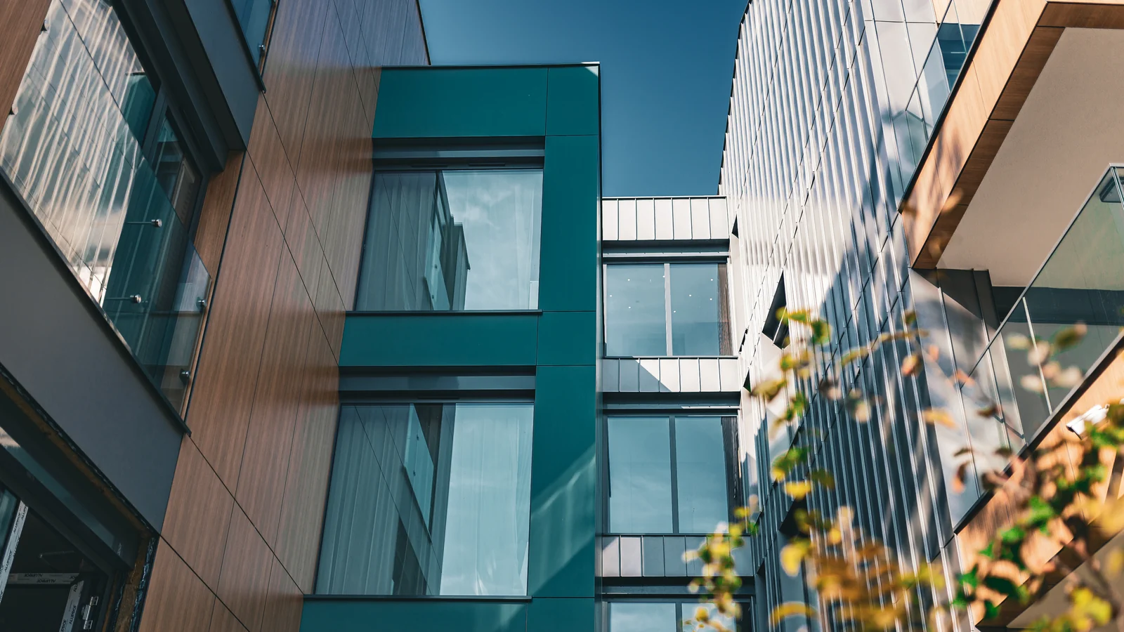 Inspiration, European project overseas: MB-79N Pro aluminum windows in a teal and wood-clad apartment building