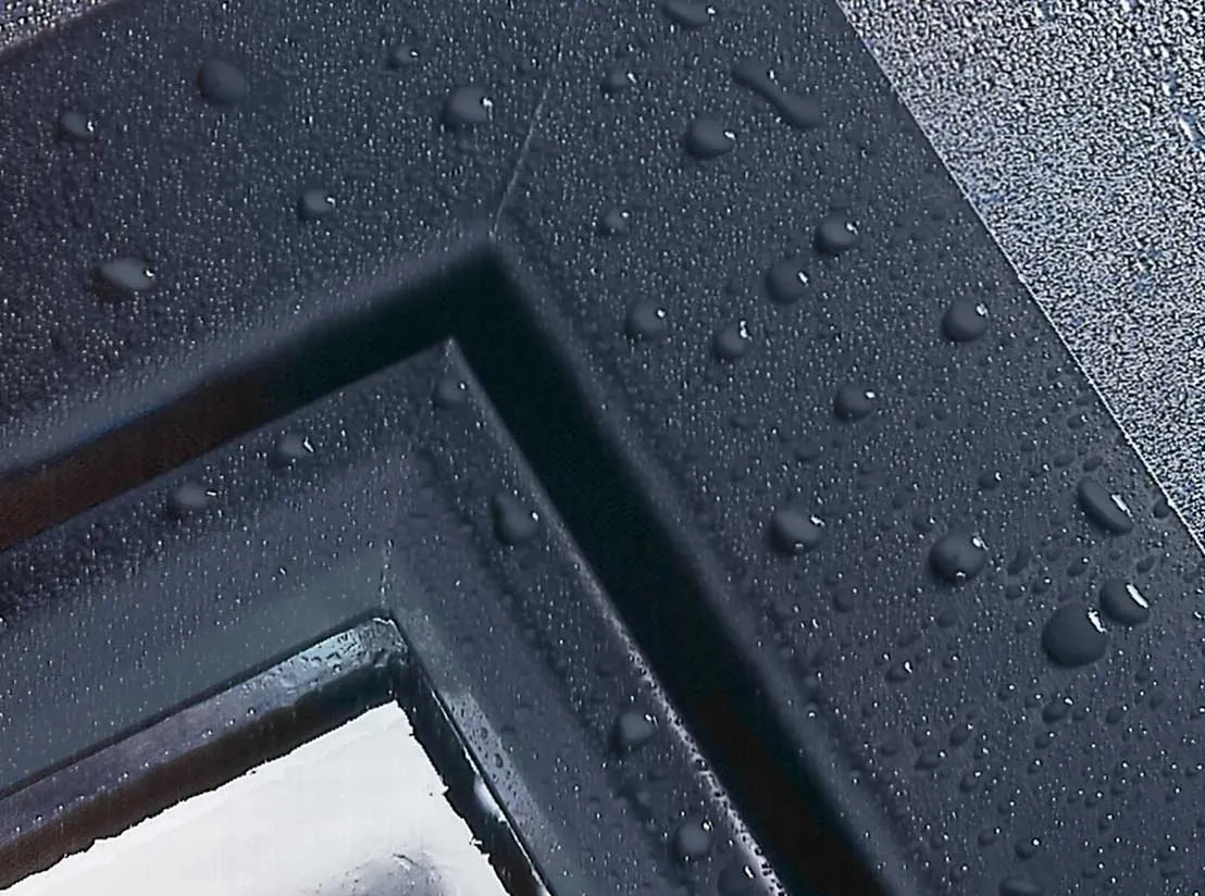 Close-up of an anthracite P-700 sash corner with water beading on the acrylic finish