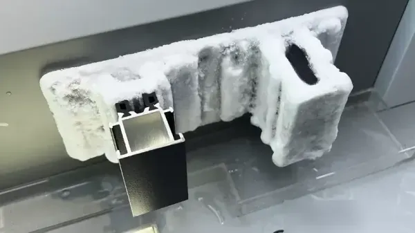Demo display: frost-covered standard aluminum frame behind a thermally broken aluminum profile that stays clear of frost in a cold test